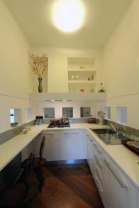 a large kitchen with white counters and a sink at La Torretta Rosa in La Spezia