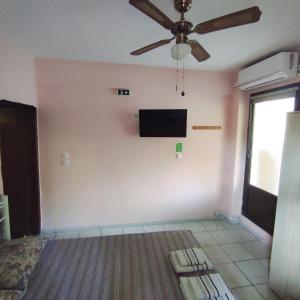 a living room with a ceiling fan and a flat screen tv at Niki's house 1 in Agia Triada
