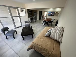 a living room with a bed and a table and chairs at uriburu45 in Malargüe
