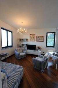 un soggiorno con divano, sedie e lampadario pendente di La Torretta Rosa a La Spezia