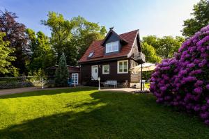 a house with purple flowers in the yard at HarzZeitRaum in Thale