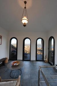 Zimmer mit Fenstern, einem Tisch und einem Kronleuchter in der Unterkunft La Torretta Rosa in La Spezia
