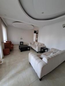 a living room with two couches and a table at Kigali Alba Home in Kigali