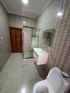 a bathroom with a toilet and a sink and a mirror at Kigali Alba Home in Kigali