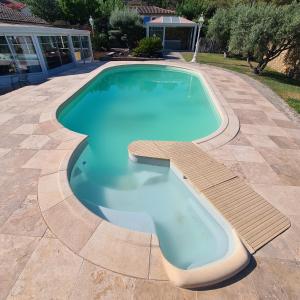 a large swimming pool with two chairs at Sunny house in Pierrefeu-du-Var