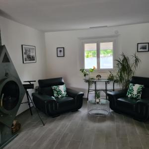 a living room with two chairs and a table at Sunny house in Pierrefeu-du-Var