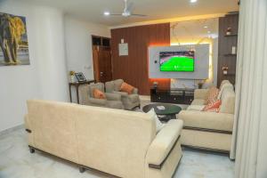a living room with couches and a flat screen tv at Coastal Haven 3 Bed Nyali in Mombasa