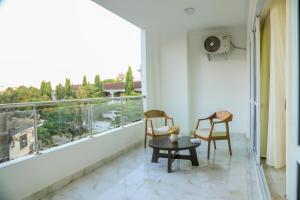 a balcony with two chairs and a table and a window at Coastal Haven 3 Bed Nyali in Mombasa