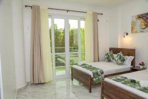 a bedroom with two beds and a window at Coastal Haven 3 Bed Nyali in Mombasa