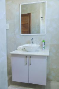 a bathroom with a white sink and a mirror at Coastal Haven 3 Bed Nyali in Mombasa +41 photos