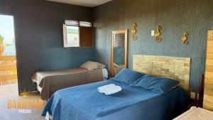 a bedroom with a blue bed with towels on it at Pousada Barumar in Lucena