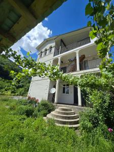a large white building with stairs in front of it at Nakra Tower GuestHouse in Mestia