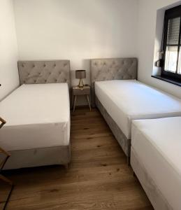 two twin beds in a room with a table at Villa Vita - MELANI in Slovenj Gradec