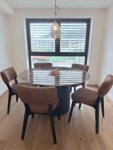 a dining room with a glass table and chairs at Villa Vita - MELANI in Slovenj Gradec