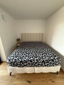 a bedroom with a bed with a black and white comforter at Villa Vita - MELANI in Slovenj Gradec +1 photo