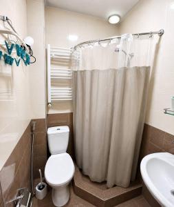 a bathroom with a white toilet and a sink at Old Tbilisi in Itʼkhvisi