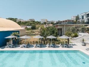 a view of a pool with chairs and umbrellas at Hotel Blue Moon in Ulcinj