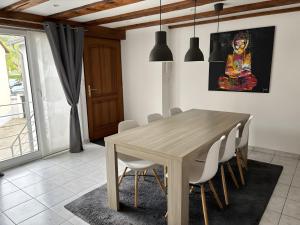 a dining room with a wooden table and chairs at Gite Loan proche Colmar in Ingersheim +8 photos