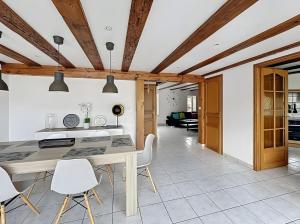 a kitchen with a table and white chairs at Gite Loan proche Colmar in Ingersheim