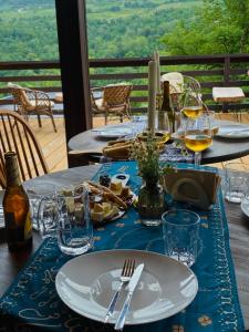 a table with a blue table cloth and wine glasses at Dakidula - დაკიდულა in Ambrolauri