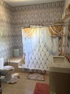 a bathroom with a shower curtain and a sink at Stays at Global Dreams in Beckford Town