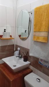 a bathroom with a sink and a mirror and a toilet at Côté Plage Kribi Studio Soleil in Kribi +23 photos