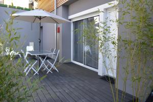 a patio with an umbrella and a table and chairs at Gite Leny proche Colmar in Ingersheim