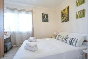 a bedroom with a white bed with towels on it at Sofia-Irini in Kalamaki
