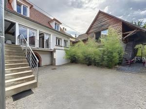 a house with a staircase next to a building at Gite Leny proche Colmar in Ingersheim