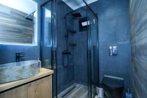 a bathroom with a glass shower with a sink and a toilet at Sofia-Irini in Kalamaki