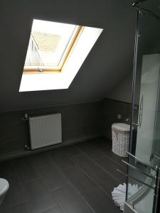 a attic bathroom with a skylight and a shower at Agroturystyka Pod Czaplami in Pieniężno +43 photos