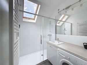 a white bathroom with a sink and a mirror at Gite Donald proche Colmar in Ingersheim +4 photos