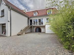 a white house with a staircase and a roof at Gite Donald proche Colmar in Ingersheim