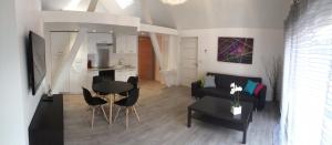a kitchen and a living room with a table and chairs at Gite Donald proche Colmar in Ingersheim