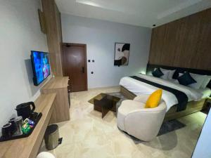 a bedroom with a bed and a chair and a television at IP Hotels And Towers in Chori