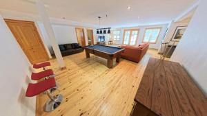 a living room with a pool table and a couch at Fiddler Lake 72 with Private spa, pool table & Pool in Mille-Isles