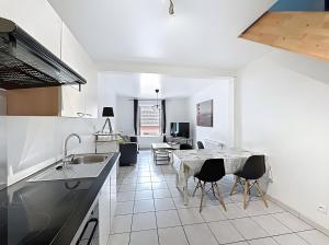 a kitchen with a table and some chairs in a room at Gite Marie proche Colmar in Ingersheim