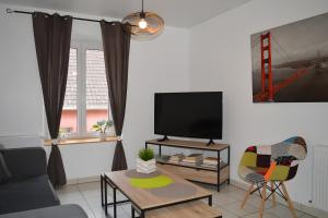 a living room with a couch and a tv at Gite Marie proche Colmar in Ingersheim