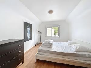 a white bedroom with a bed and a dresser at Gite Marie proche Colmar in Ingersheim
