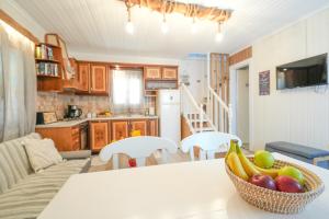 a kitchen with a table with a bowl of fruit on it at Sofia-Irini in Kalamaki