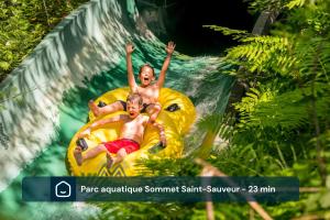 two men riding on a raft on a water slide at Fiddler Lake 72 with Private spa, pool table & Pool in Mille-Isles