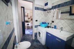 a bathroom with a washing machine and a sink at Appartamento Buggerru Blue Nest in Buggerru