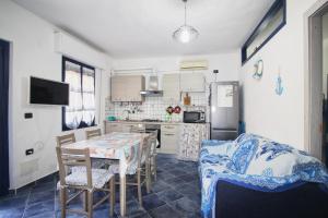 a kitchen with a table and chairs and a refrigerator at Appartamento Buggerru Blue Nest in Buggerru +35 photos