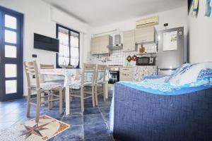 a kitchen and dining room with a table and chairs at Appartamento Buggerru Blue Nest in Buggerru