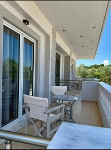 a balcony with tables and chairs on a building at VILLA Konstantinos in Agios Georgios