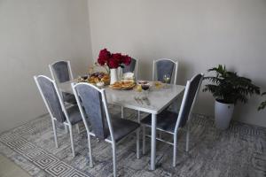 a dining room table with a white table and chairs at Khan Dobo in Bokonbayevo +13 photos