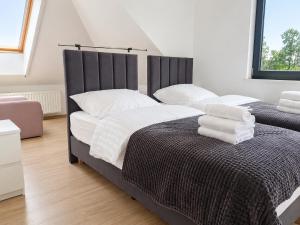 a bedroom with two beds with white towels on them at Wichrowe Wzgórze dom na wyłączność 5 sypialni Kraków 50 min in Tworkowa