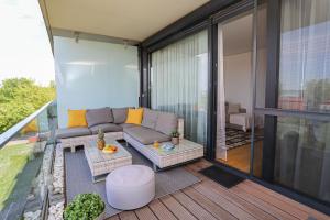 a balcony with a couch and a table at BL Waterside 55 in Balatonlelle