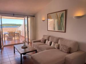 a living room with a couch and a table at Riera Rossello 2 by SOM menorca in Fornells