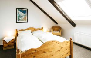 a bedroom with a wooden bed with white sheets at Herzog Friedlich Hotel Garni in Friedrichstadt +17 photos